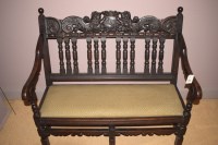 Lot 834 - A dark stained carved bench seat, the cresting...