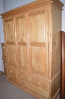 Lot 760 - A modern pine three door wardrobe fitted...