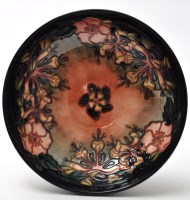 Lot 1121 - Moorcroft: a floral pattern bowl on blue/black...